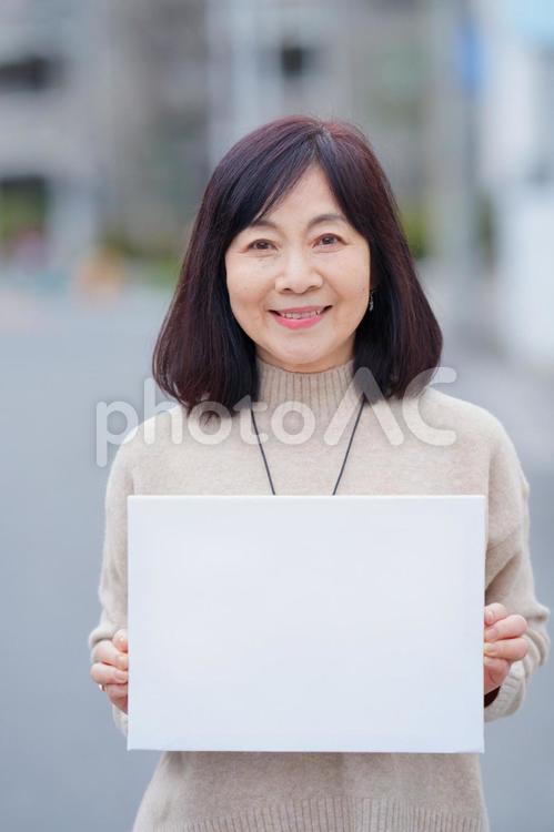 屋外で白い紙を持っている高齢女性 女性,おばあちゃん,1人の写真素材