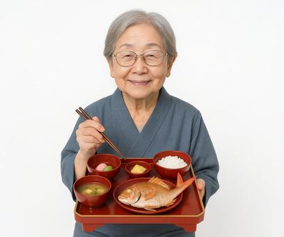 お祝い料理を持つ高齢女性の笑顔 お祝い料理を持つ高齢女性の笑顔の写真
