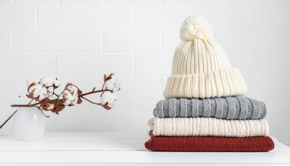 たたまれた冬物の服の写真