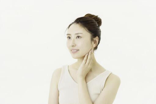 白背景の首筋を触る若い日本人女性 女性,白背景,美容の写真素材
