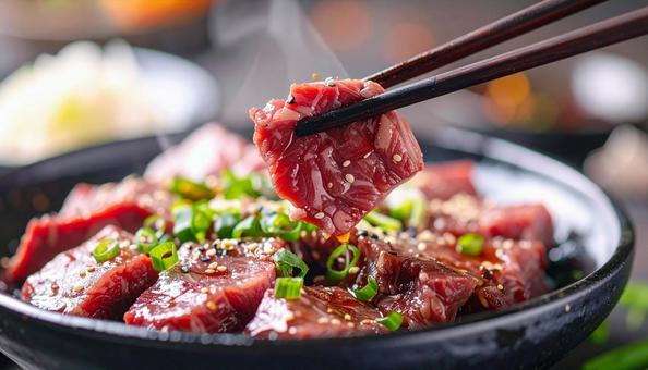 焼肉用の生肉を箸でつまむ 焼肉用の生肉を箸でつまむの写真