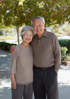 緑の中を歩くシニア世代の写真