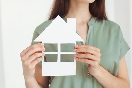 家の切り抜きを持つ女性スタッフの手元 保険業,事務職,接客業の写真素材