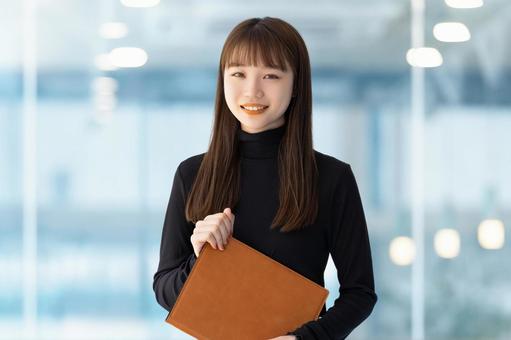 バインダーを持つ笑顔の女性 バインダーを持つ笑顔の女性 女性,笑顔,ビジネスの写真素材