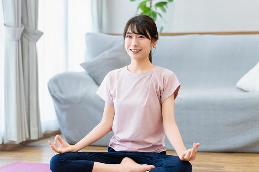 自宅のリビングでヨガをする女性 自宅のリビングでヨガをする女性 女性,ヨガ,ストレッチの写真素材