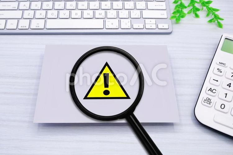 注意マークを虫眼鏡で拡大 注意,警戒,注意喚起の写真素材