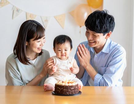 赤ちゃんの誕生日をお祝いする若い夫婦 赤ちゃんの誕生日をお祝いする若い夫婦の写真