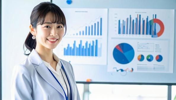 グラフの前に立つ日本人女性会社員 グラフの前に立つ日本人女性会社員の写真
