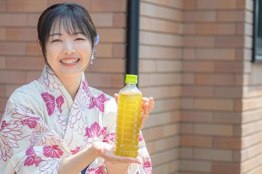 爽やかに茶を差し出す浴衣女性 笑顔,浴衣,女性の写真素材