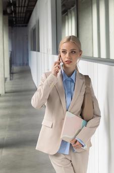 オフィスの通路で電話するビジネスウーマン ビジネスウーマン,ビジネス,女性の写真素材