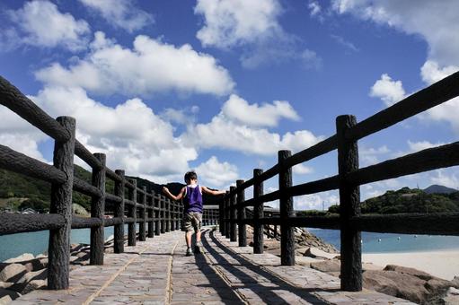 ＜素材＞海辺の遊歩道を散歩する男の子 子供,海,空の写真素材