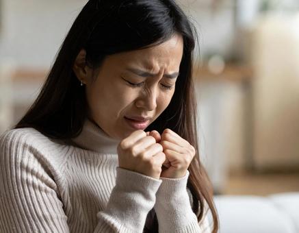 必死に涙をこらえる若い女性の感情表現 必死に涙をこらえる若い女性の感情表現の写真