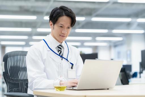 実験をする白衣の若い男性研究者 実験をする白衣の若い男性研究者 研究,実験,サイエンスの写真素材