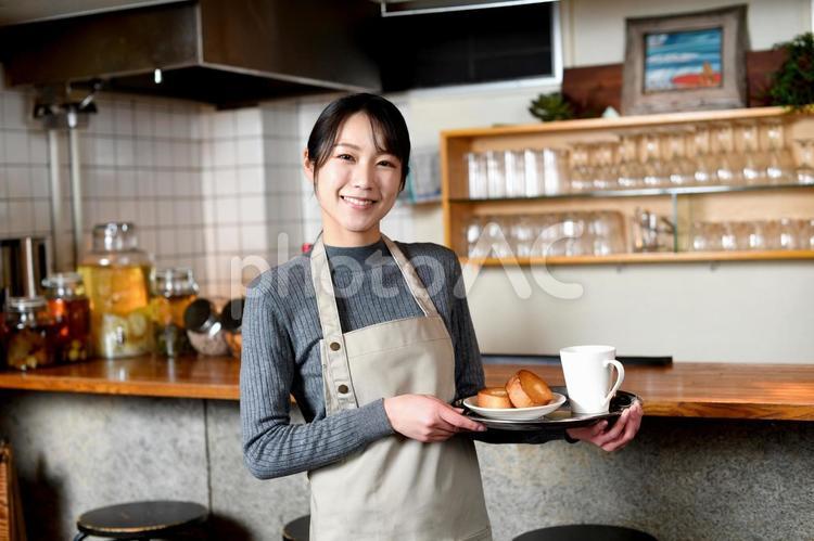 飲食店で働くアジア人の若い女性の店員 カフェ,店員,スタッフの写真素材