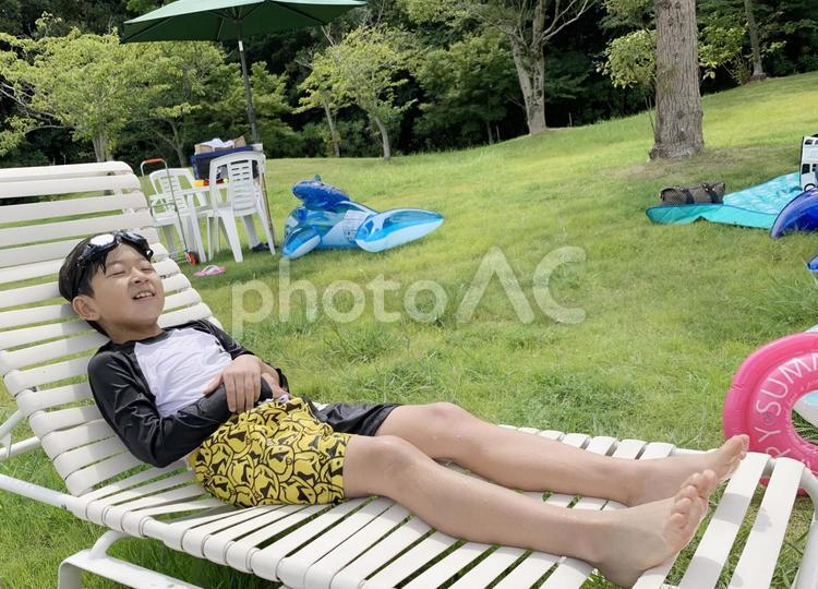 プールサイドのベンチでくつろぐ男の子 子供,プール,プールサイドの写真素材