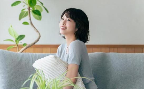 リビングのソファに座る笑顔の女性 リビングのソファに座る笑顔の女性 女性,ソファ,微笑むの写真素材