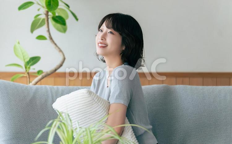 リビングのソファに座る笑顔の女性 女性,ソファ,微笑むの写真素材