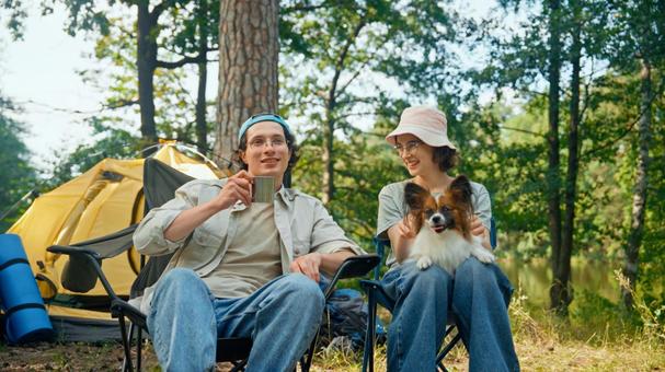 森の中で笑顔で会話をする男女 男女,外国人,犬の写真素材