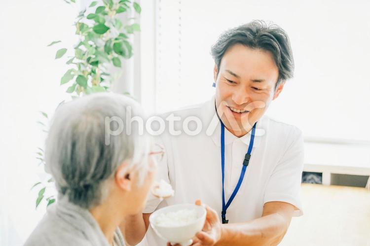 食事介助する男性スタッフ 食事介助,介護食,高齢者の写真素材