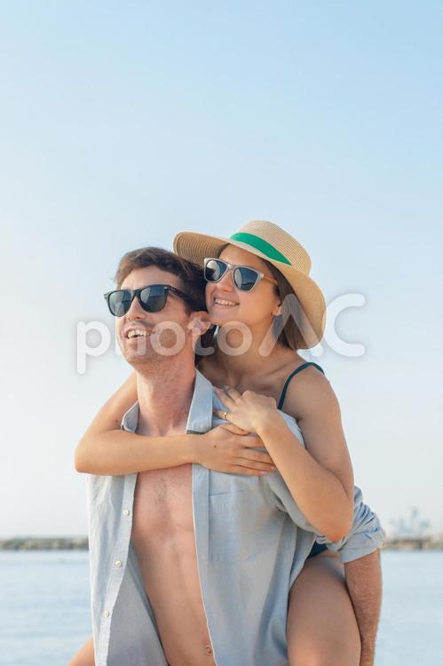海辺でで彼女をおんぶしている彼氏 カップル,男女,男性の写真素材