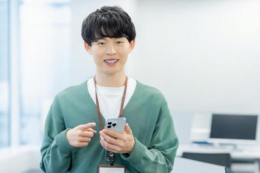 オフィスでスマホを使うビジネスマン スマホ,ビジネスマン,笑顔の写真素材