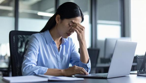仕事で失敗して悩む女性社員 仕事で失敗して悩む女性社員の写真