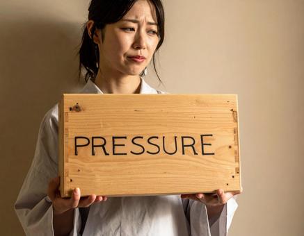 プレッシャーに耐える女性 プレッシャーに耐える女性の写真