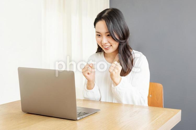 PCでネット中継を見るアジア人女性01 女性,pc,笑顔の写真素材