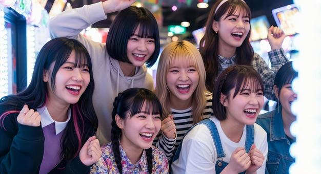 ゲームセンターで盛り上がる女子高生たち ゲームセンターで盛り上がる女子高生たちの写真