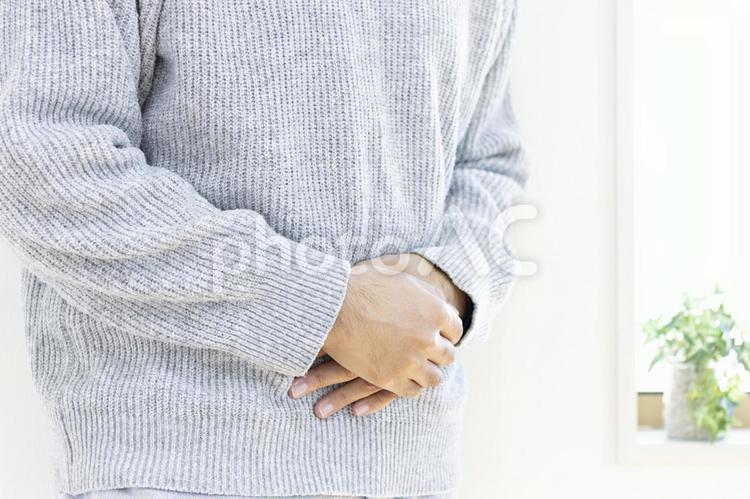 お腹を押さえて苦しむセーターを着た男性 病気,腹痛,男性の写真素材