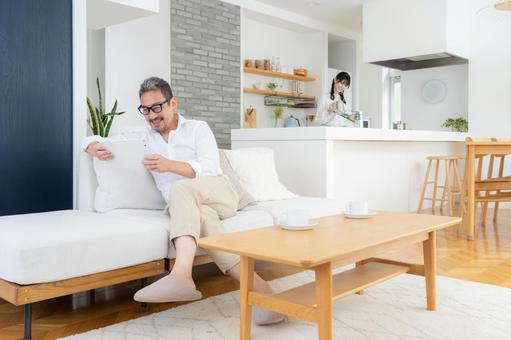 リビングでタブレットを見るミドルの夫婦 リビングでタブレットを見るミドルの夫婦 夫婦,家族,ミドルの写真素材