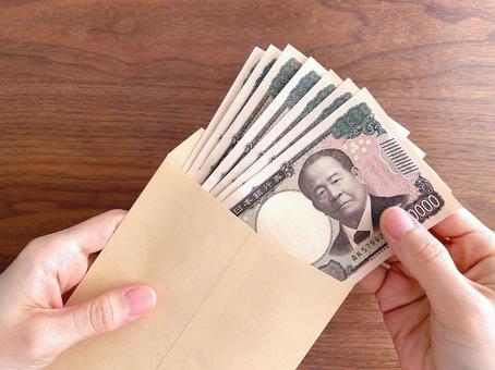 机上で封筒に入ったお金を持つ女性の手 お金,持つ,手の写真素材