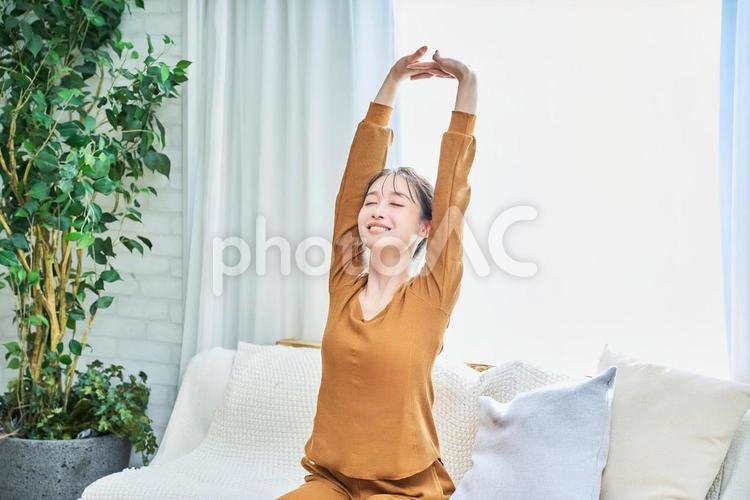 ルームウェアを着て部屋でくつろぐ若い女性 女性,若い,笑顔の写真素材
