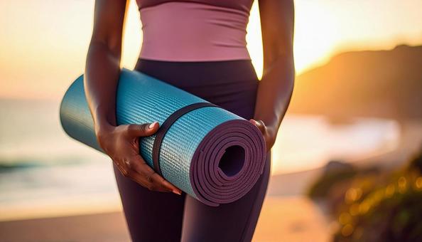 ヨガマットを持ちヨガレッスンに向かう女性 ヨガマットを持ちヨガレッスンに向かう女性の写真