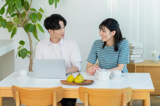 パソコンを見るカップル ノートパソコン,笑顔,カップルの写真素材