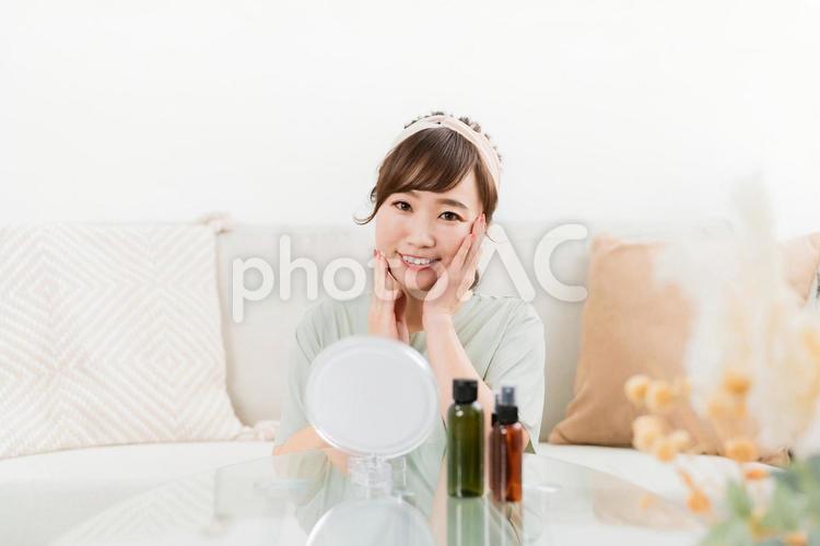 鏡を見ながらスキンケアをするアジア人女性 スキンケア,アンチエイジング,化粧水の写真素材