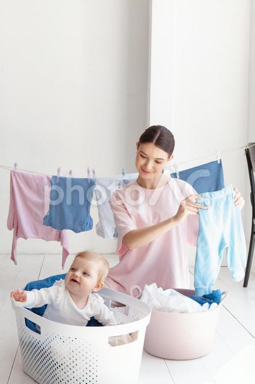 洗濯物を持って微笑む女性と赤ちゃん 親子,女性,人物の写真素材