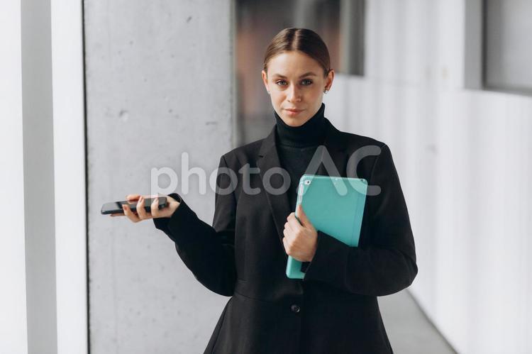 タブレットとスマホを持つカメラ目線女性 女性,スマートフォン,タブレットの写真素材