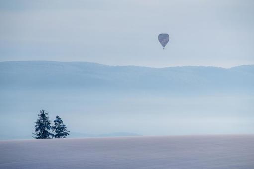 極寒の冬空を静かに漂う熱気球 丘,熱気球,雪原の写真素材