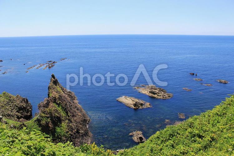 切り立った岩と青い海と水平線 水平線,切り立った,綺麗な海の写真素材