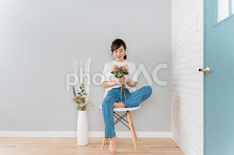 花束を持つ椅子に座ったアジア人女性 花,フローラル,椅子の写真素材