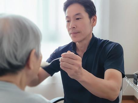 食事のサポートをする介護ヘルパーの男性 男性,笑顔,ホームヘルパーの写真素材