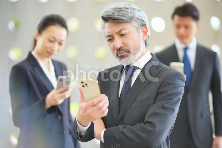 スマートフォンを持って立つ上司と部下 ビジネスマン,チーム,同僚の写真素材