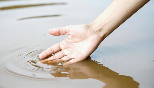 泥水を触る手の写真