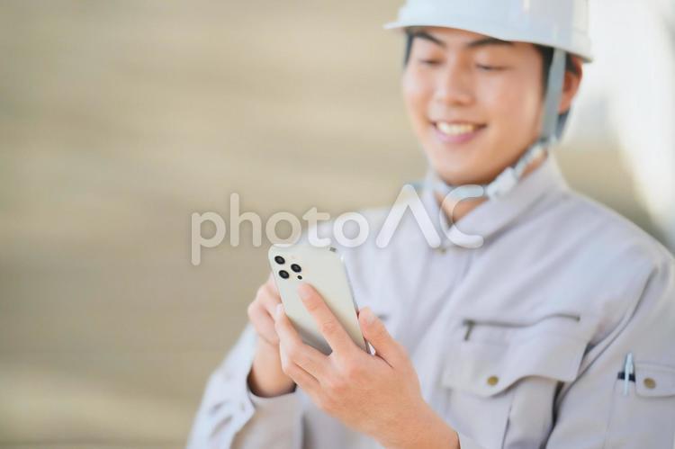 笑顔でスマホを見る男性 男性,仕事,スマートフォンの写真素材