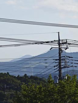 電線越しの青い山並み 電柱,電線,空の写真素材