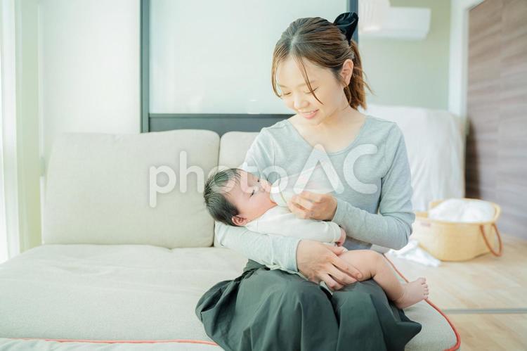 ソファーで赤ちゃんにミルクをあげるママ ママ,母親,赤ちゃんの写真素材