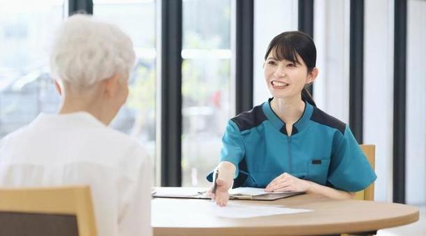 介護施設の説明をするアジア人介護士 高齢者,介護施設,説明の写真素材