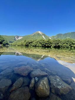 水面から見た焼岳の絶景 水面から見た焼岳の絶景の写真