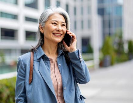 街中で電話をかける女性の写真